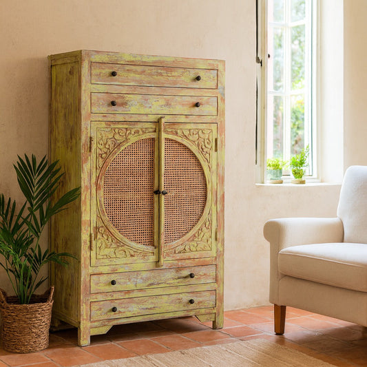 Vintage-style cabinet with decorative design in a room with a plant and chair.