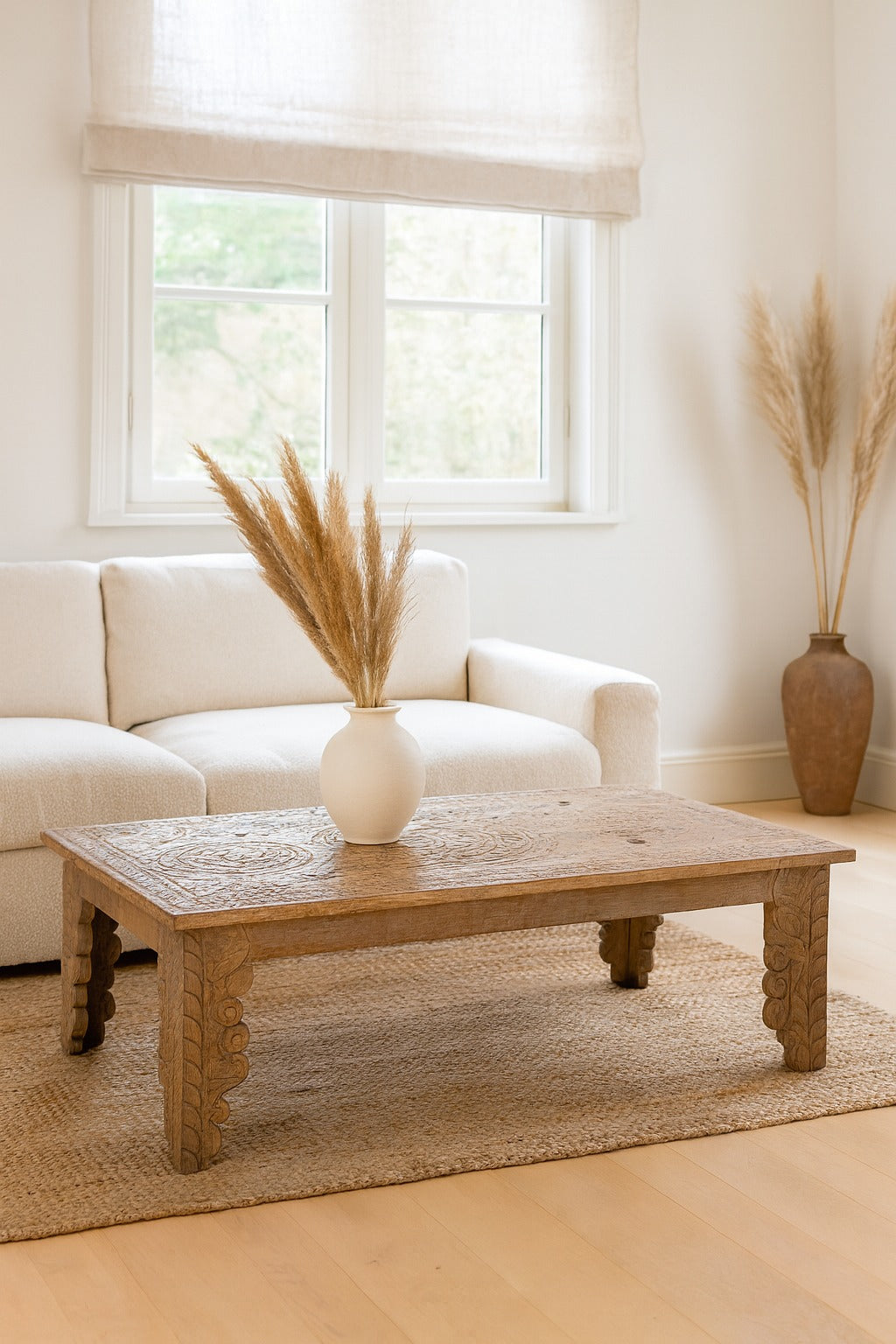 Living room with a wooden coffee table, white sofa, and decorative vases.