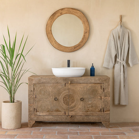 Bathroom with wooden vanity, round mirror, and bathrobe