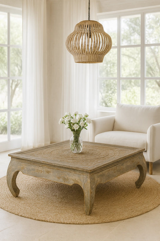 Living room with a wooden coffee table, white sofa, and decorative lamp.